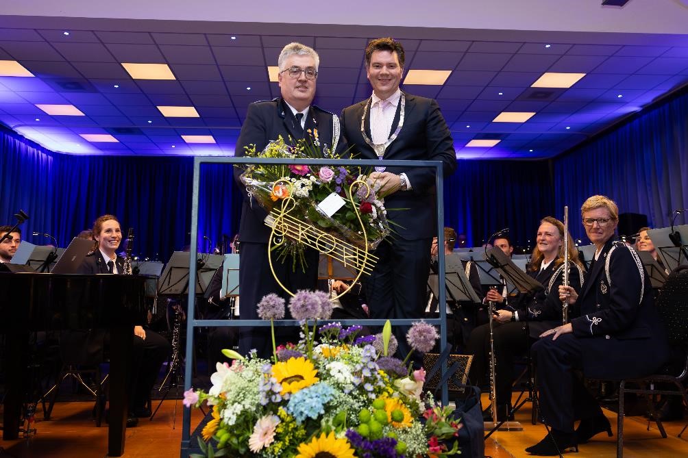De heer Willy Martens en burgemeester Alain Krijnen tussen de leden van de Koninklijke Oude Harmonie Eijsden tijdens het jubileumconcert